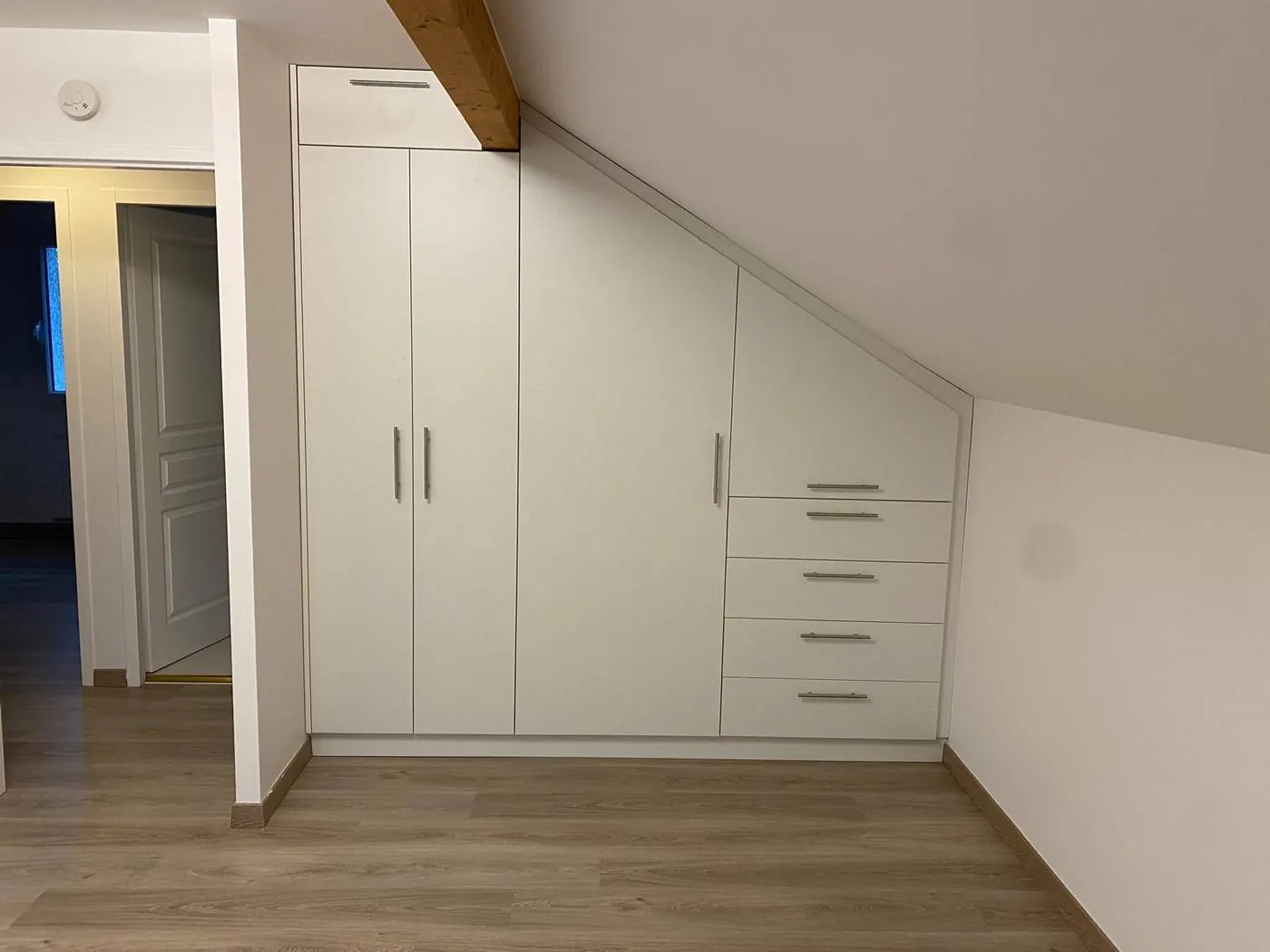 Bespoke wardrobe under a sloped ceiling, closed fronts